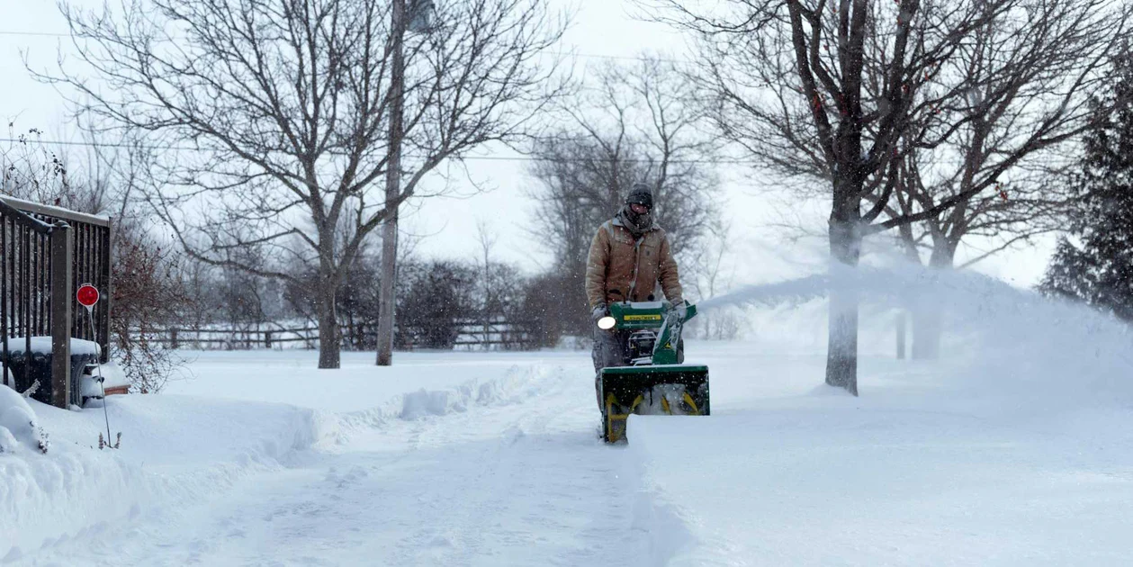 man pushing snowblower